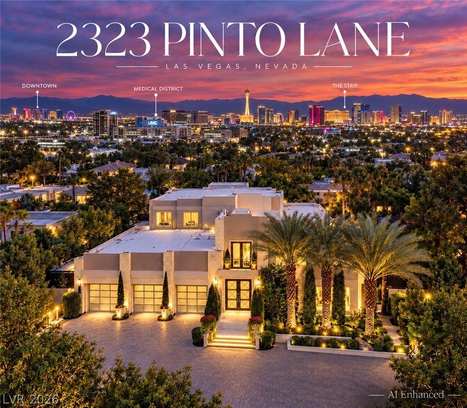 Luxury Las Vegas home with illuminated facade and palm-lined grounds overlooking the Strip at dusk.