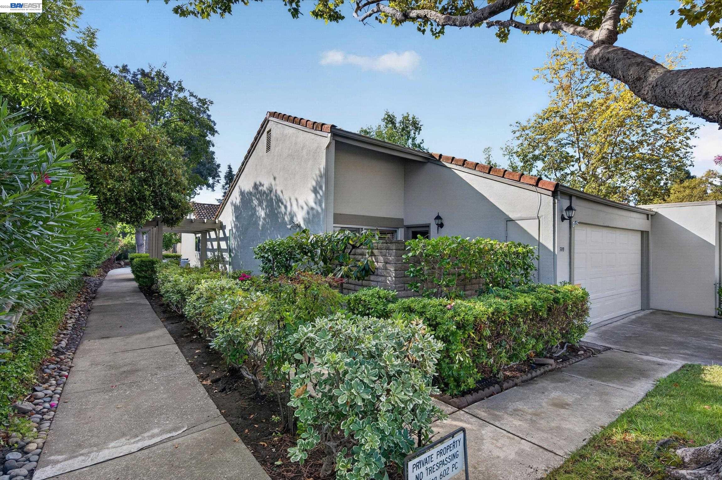 509 Tampico home with landscaped walkway, shrubs, and attached garage.