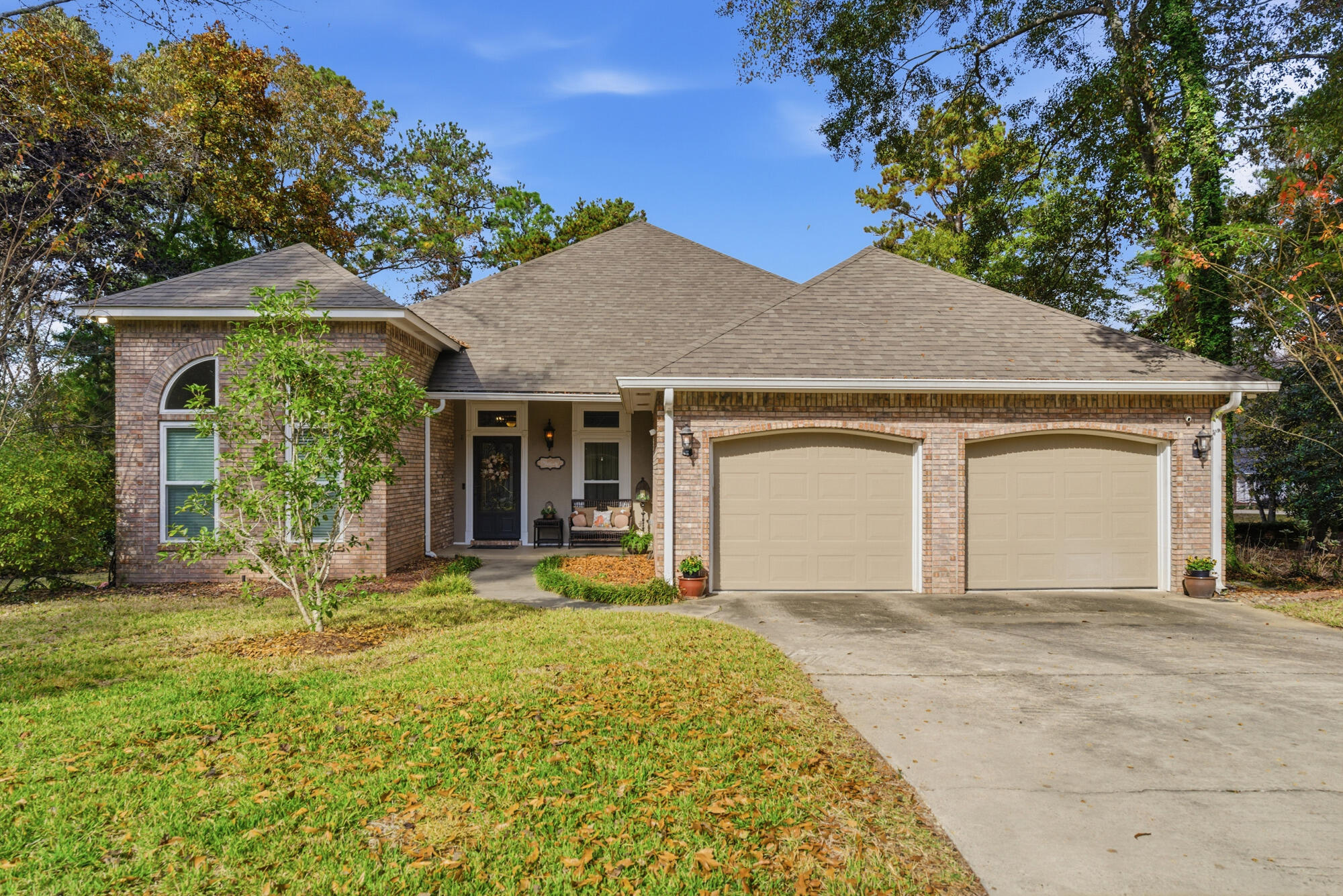 Brick house with a two-car garage, arched front window, and covered entry.