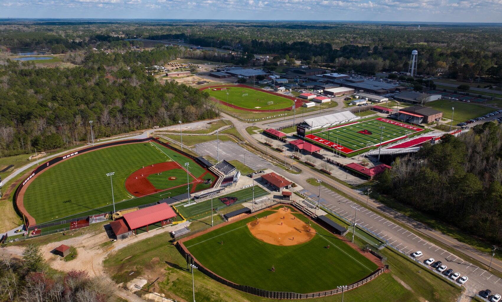 Aerial view of a sports complex with a Panthers football stadium, baseball fields, and soccer pitches.
