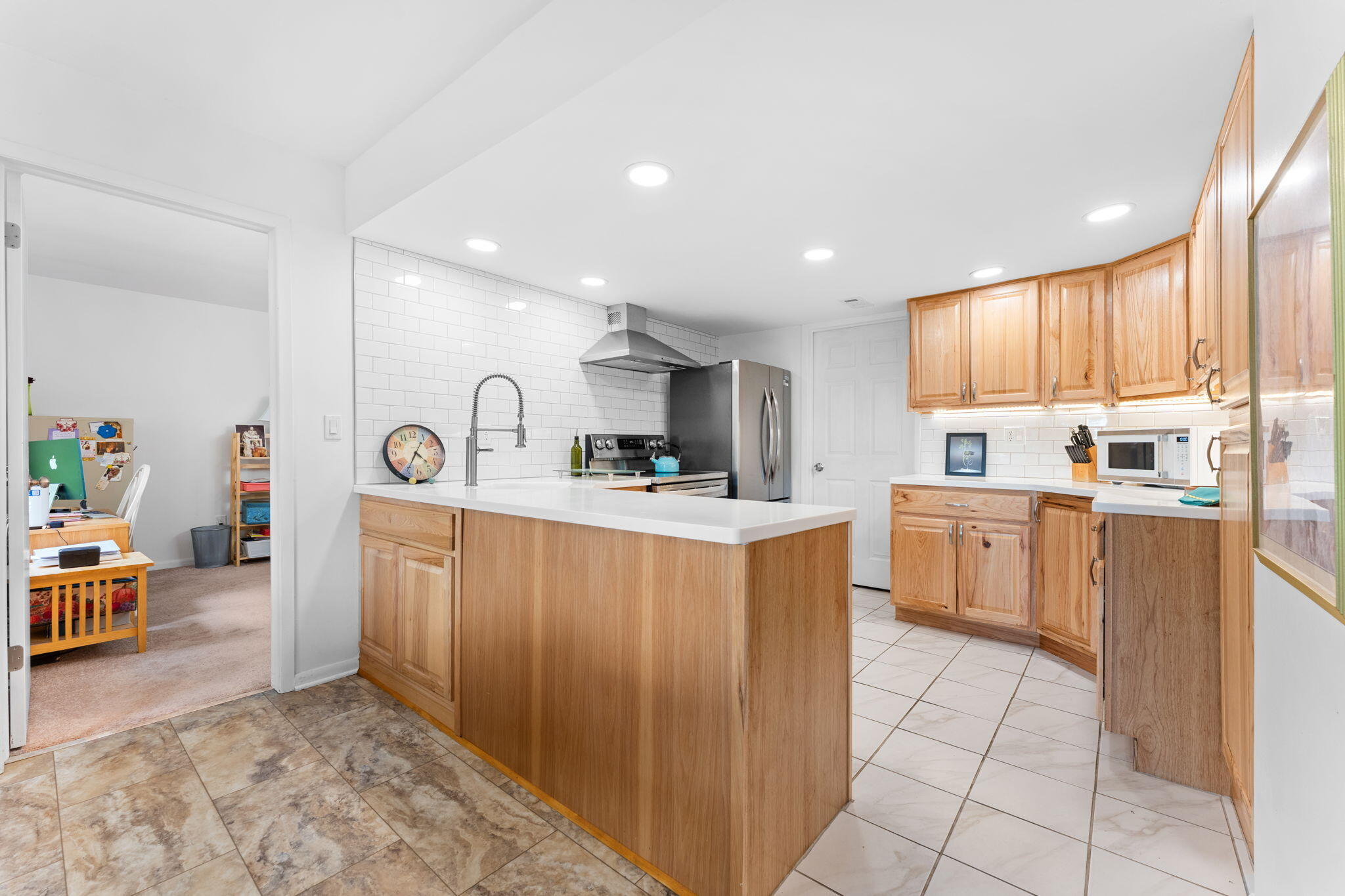 Kitchen with a large wood island, honey-colored cabinets, and stainless steel appliances.