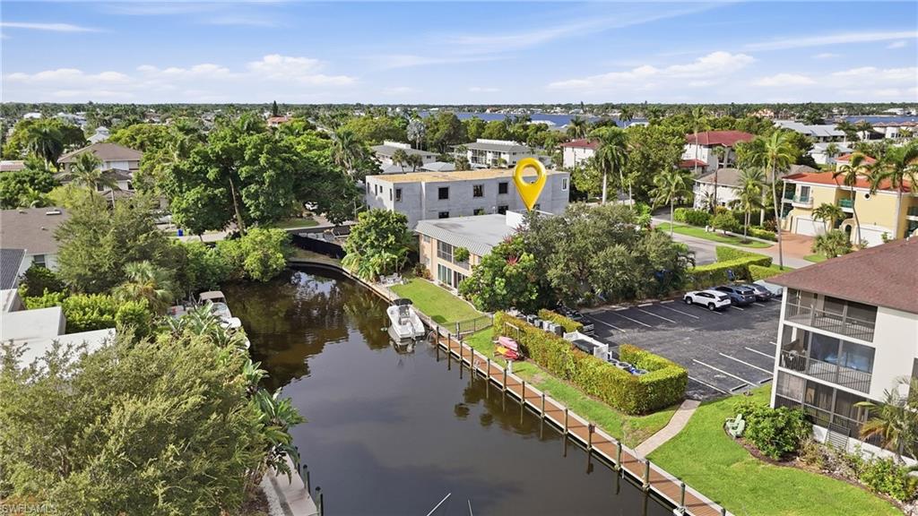Aerial view of a canal-front property with a private dock and boats.