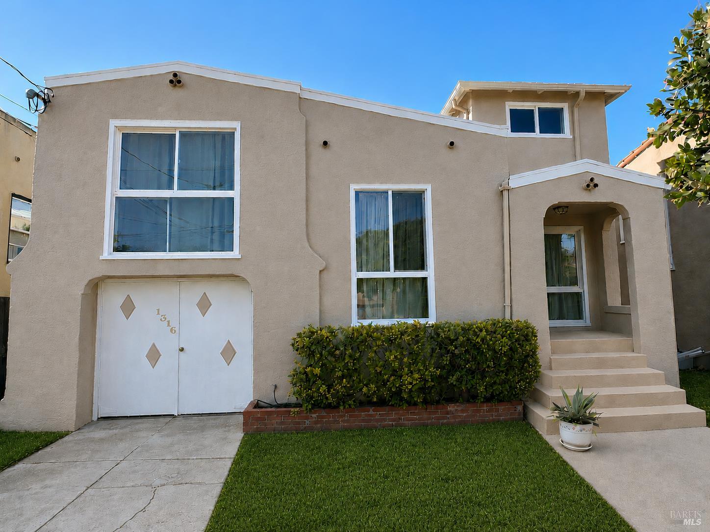 Beige stucco house with garage marked 1316, covered entry, front hedge, and lawn.