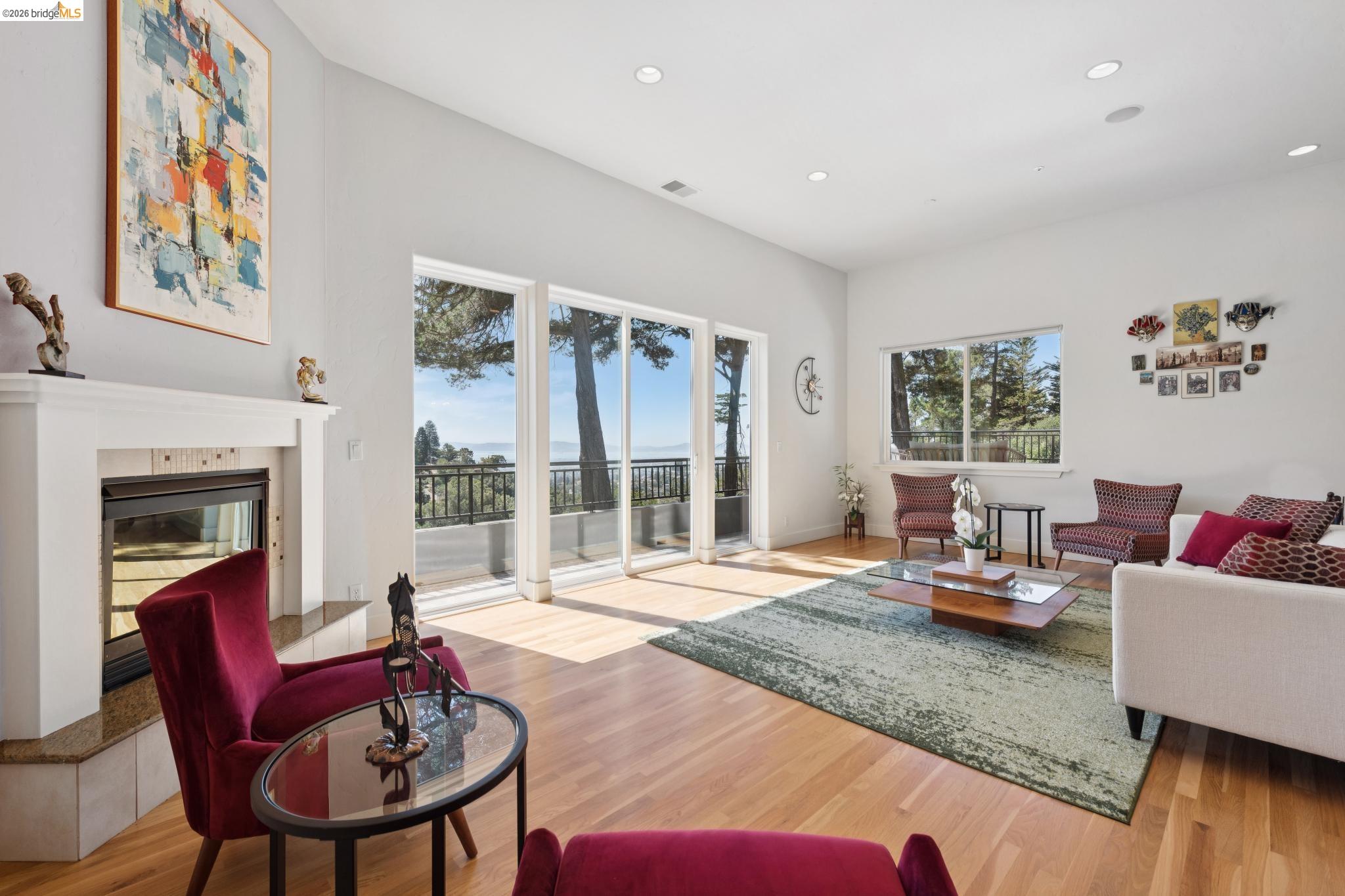 Furnished living room with a fireplace, balcony access, and a water view through large windows.