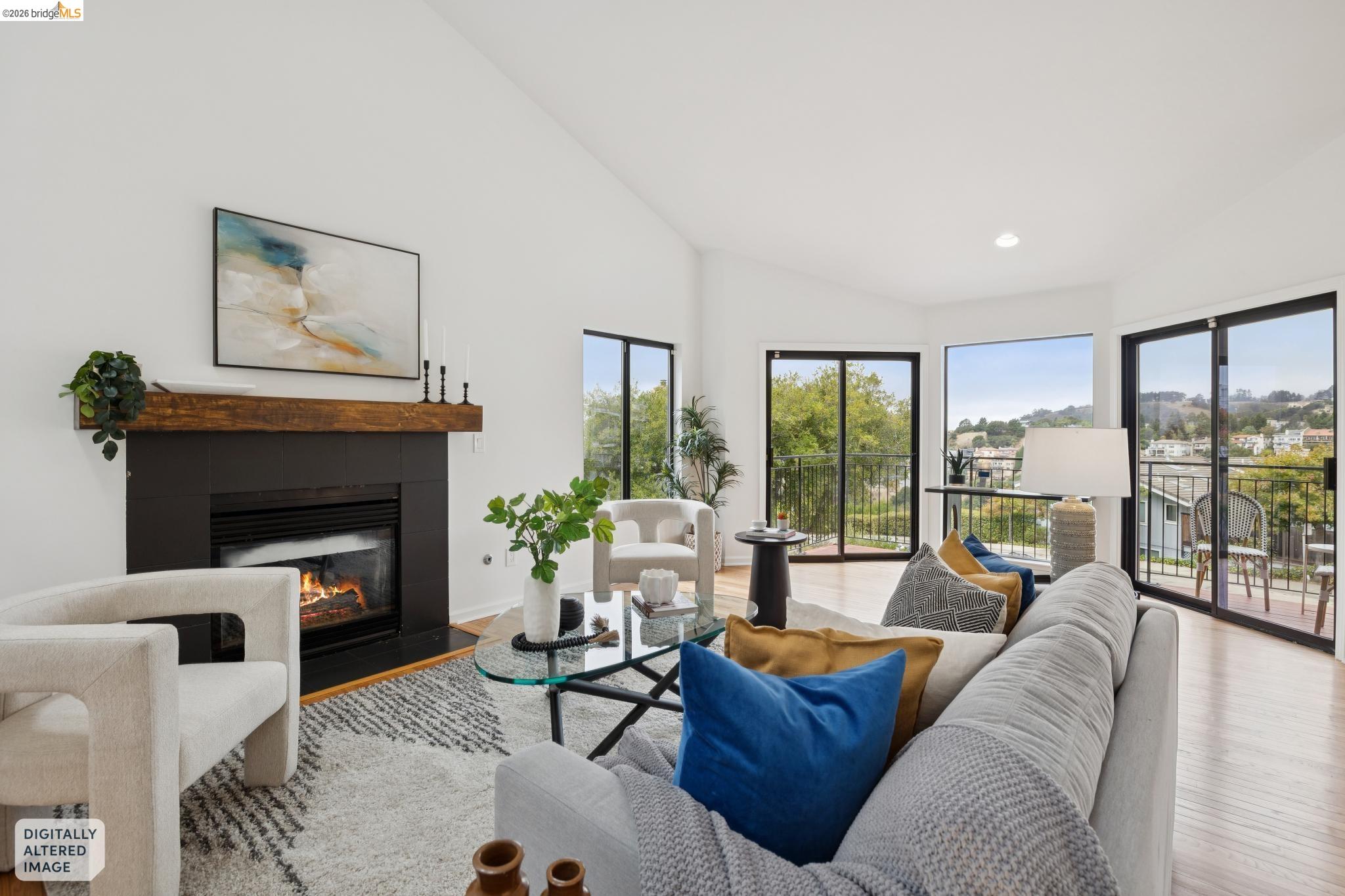 Staged living room with fireplace, vaulted ceiling, and glass doors opening to a balcony.