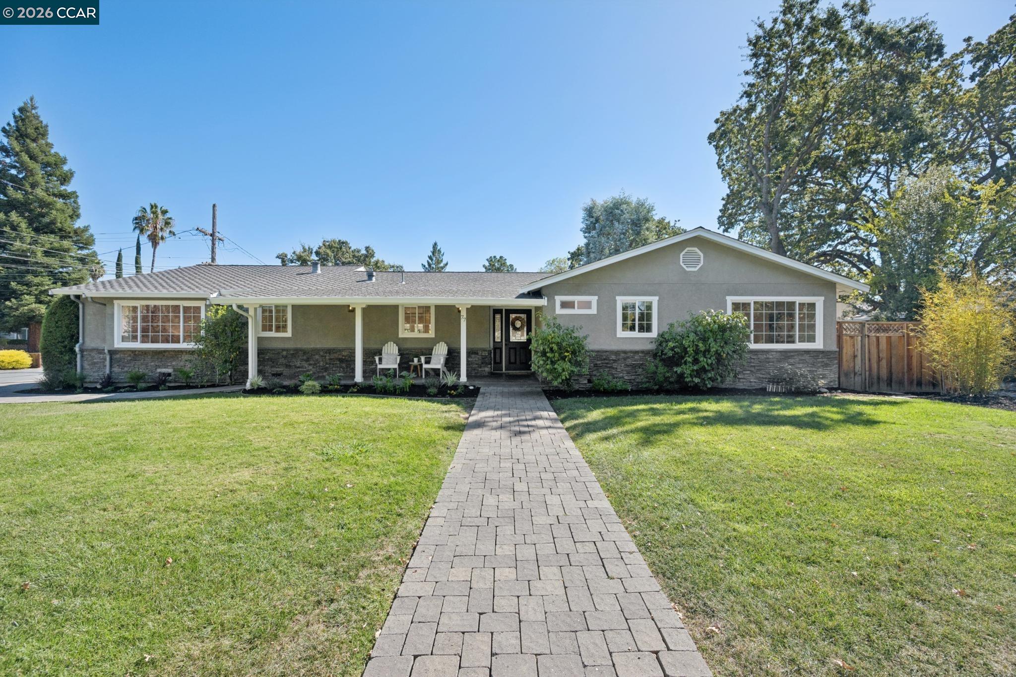 Front exterior of 77 Jerome Ct, with a covered porch and long paver walkway.