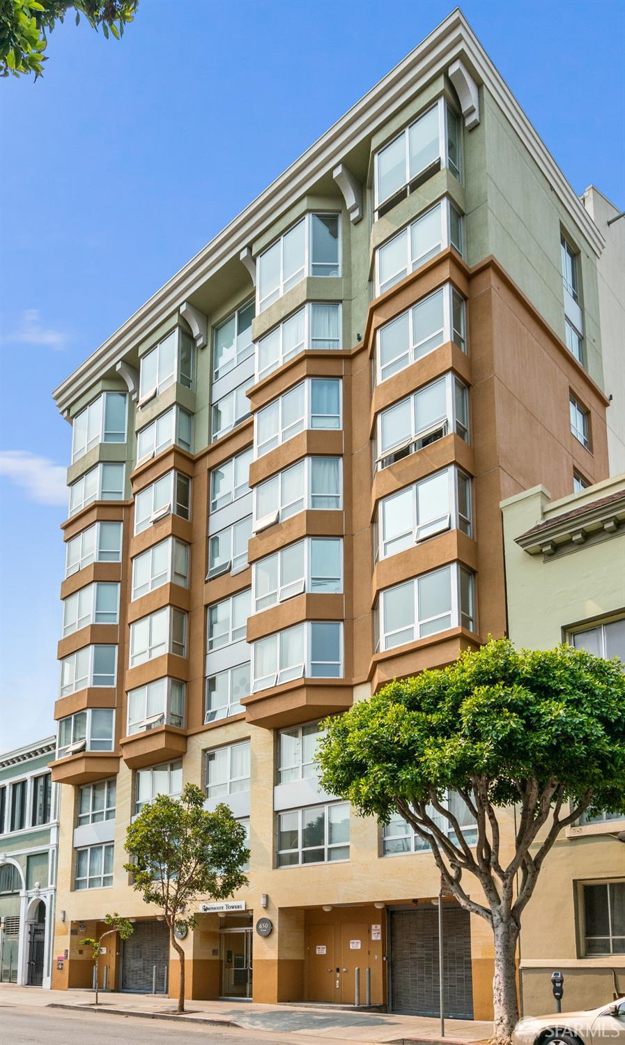 Residential building at 650 with tan and green facade sections and rows of bay windows.