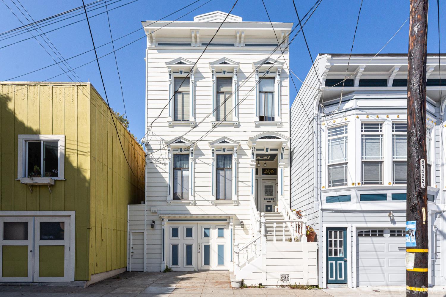 White San Francisco home with ornate trim, tall windows, and front staircase