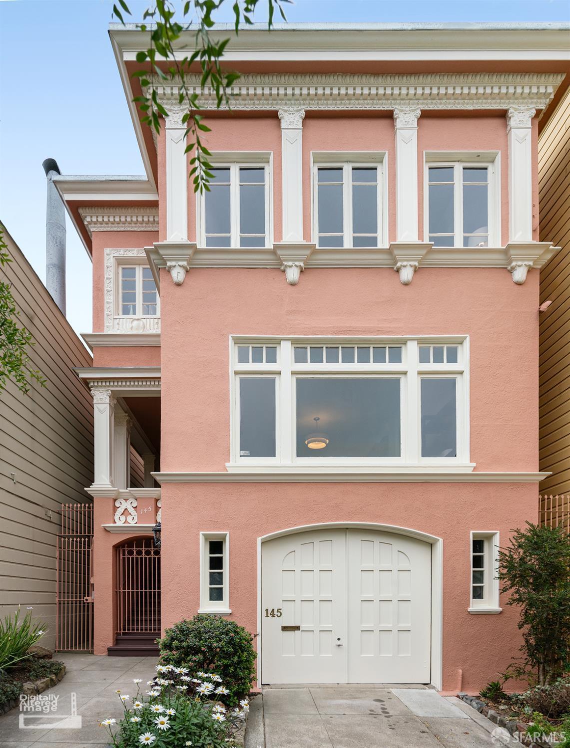 Pink house with ornate white trim, tall windows, and a white garage door marked 145.