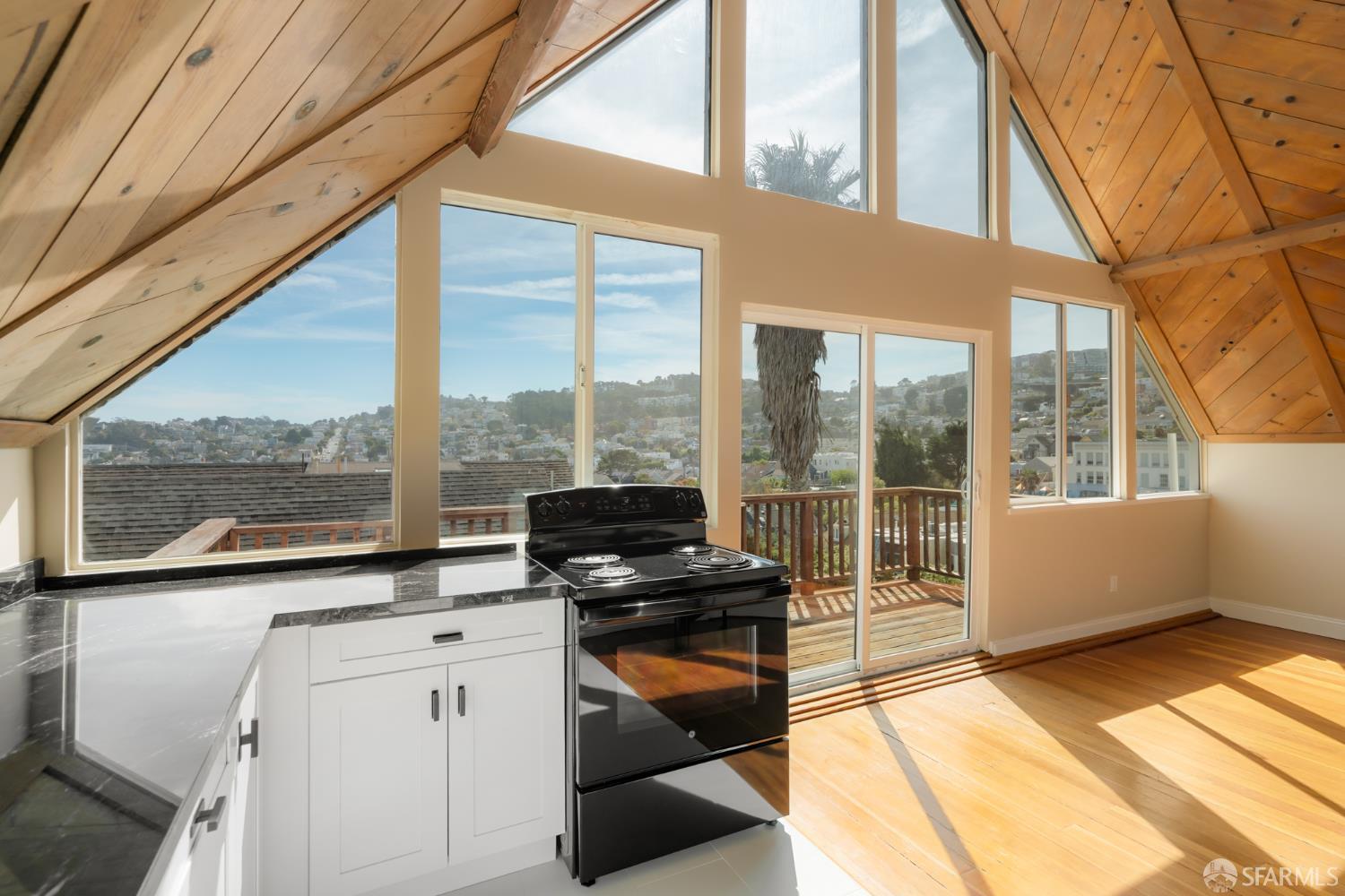 Kitchen with vaulted wood ceiling, large windows, and hillside city views.
