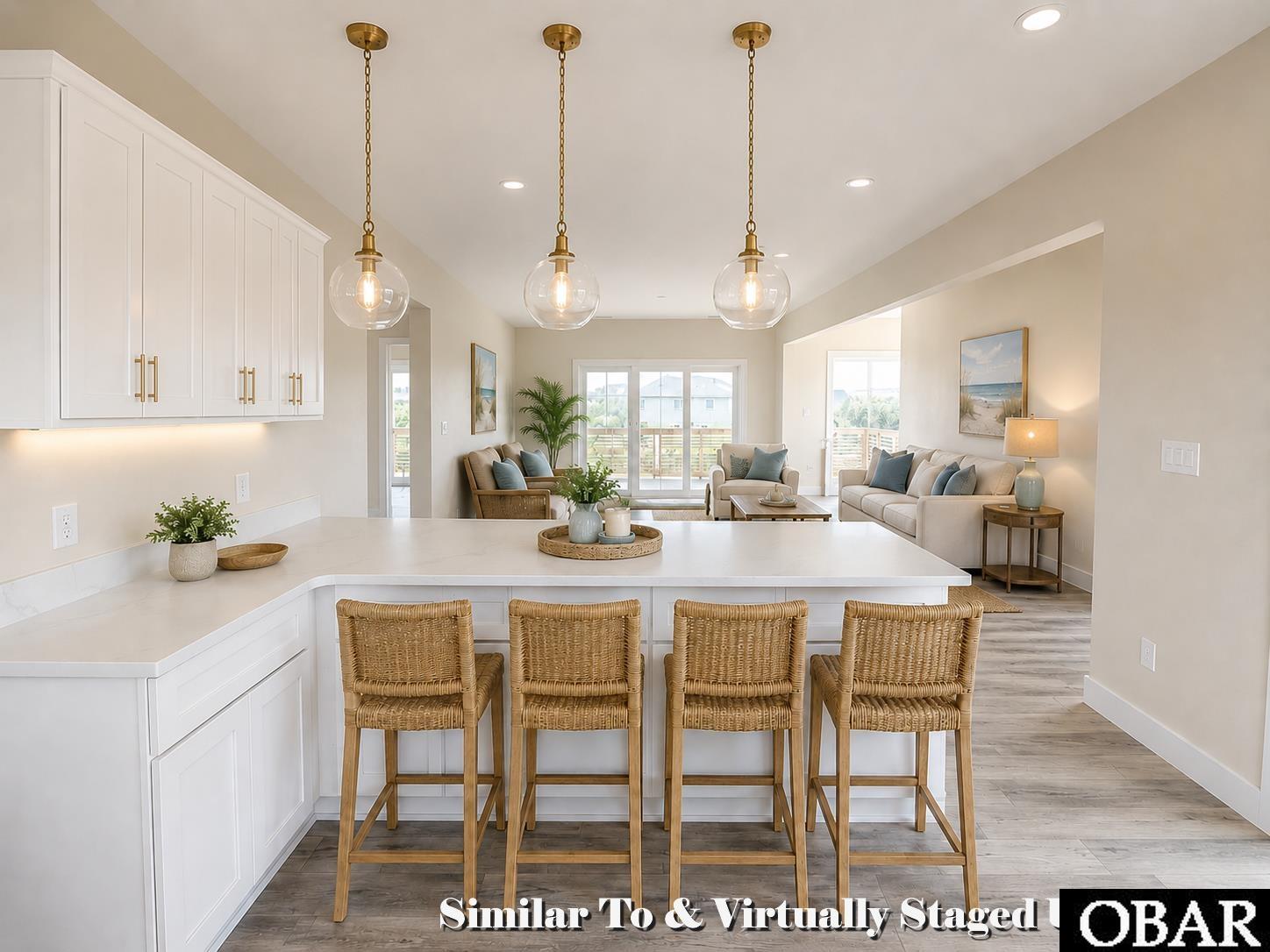 Open kitchen and living room with a large island, wicker bar stools, and seating by glass doors.
