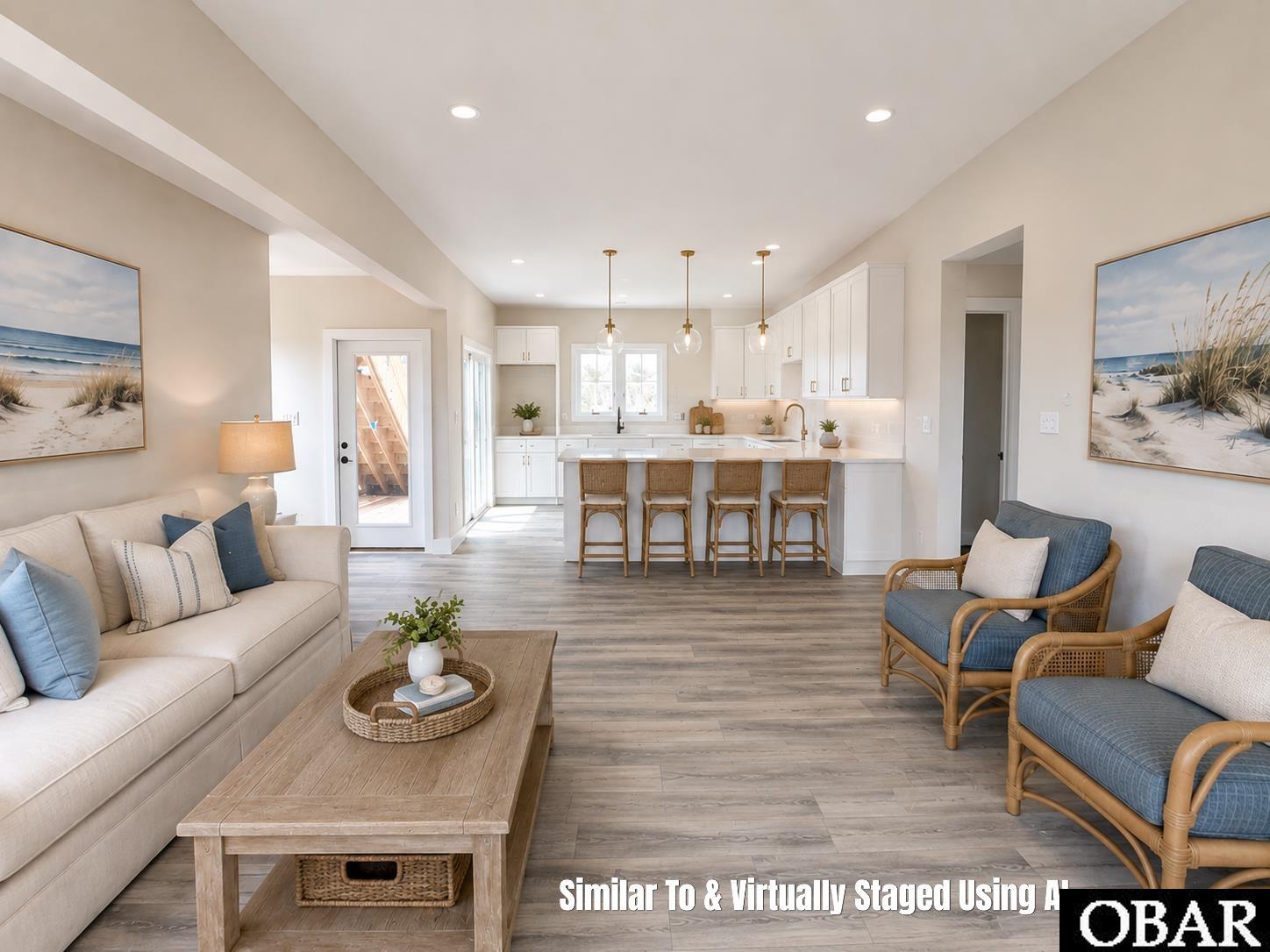 Open-plan living room and kitchen with a white island, bar stools, neutral sofas, and blue accent chairs.