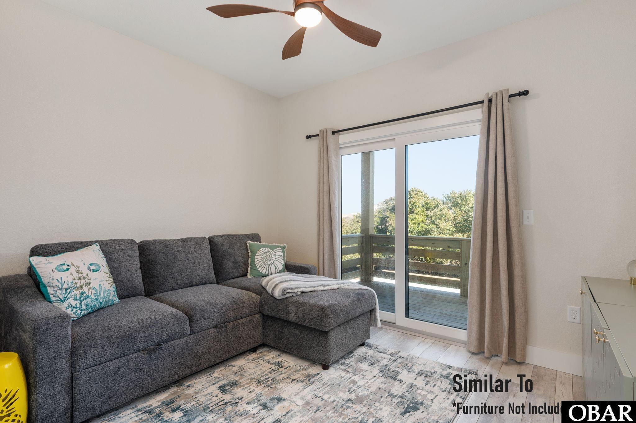 Living room with gray sectional sofa and sliding doors opening onto a deck.