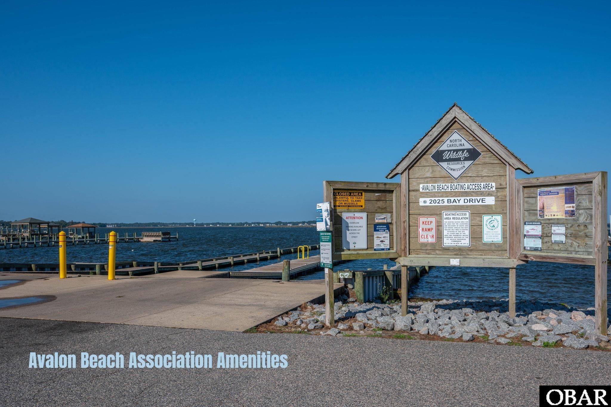 Avalon Beach boating access area with docks and a waterfront information board.