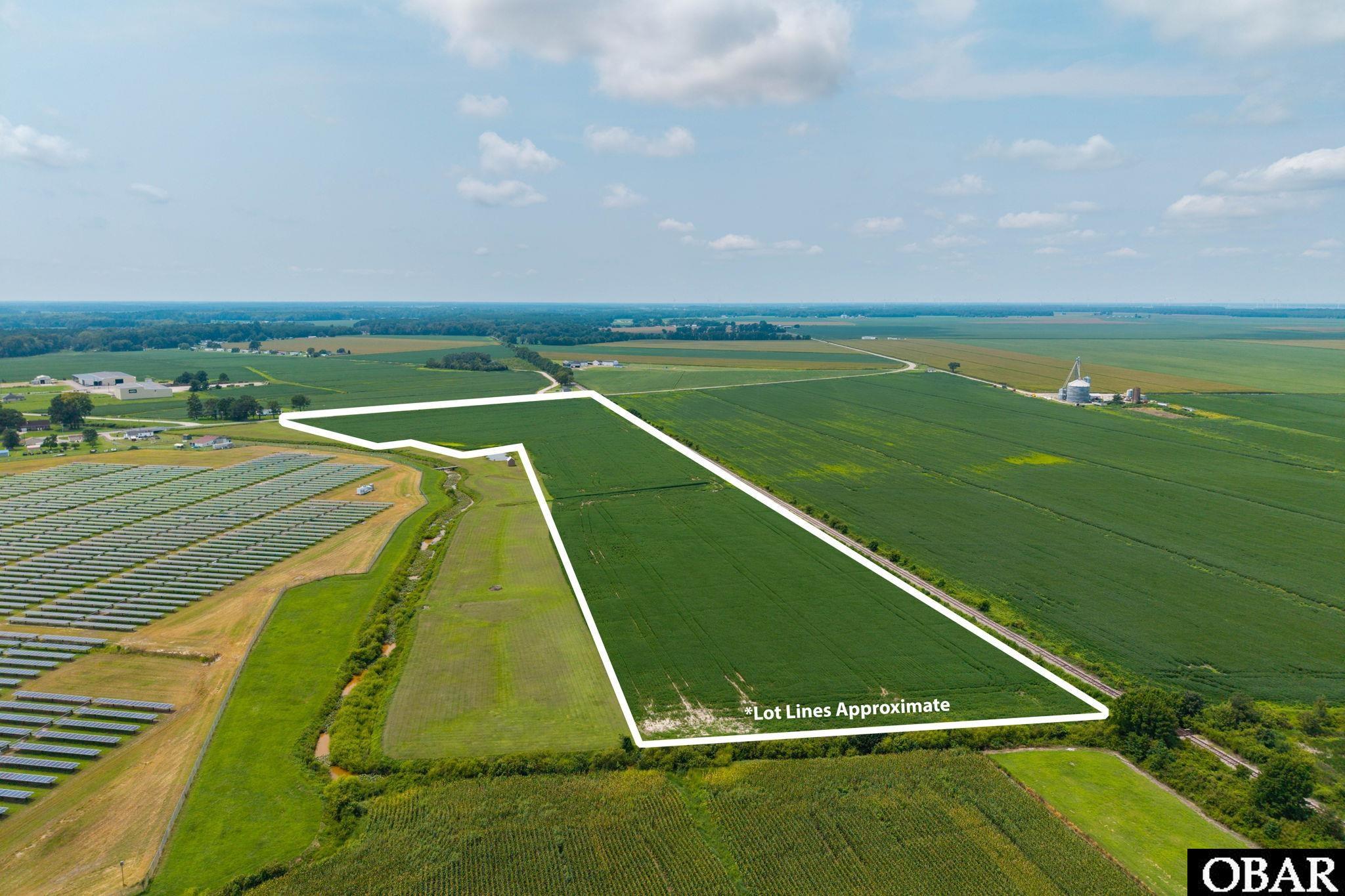 Aerial view of a marked agricultural parcel bordered by fields, with solar panels nearby.
