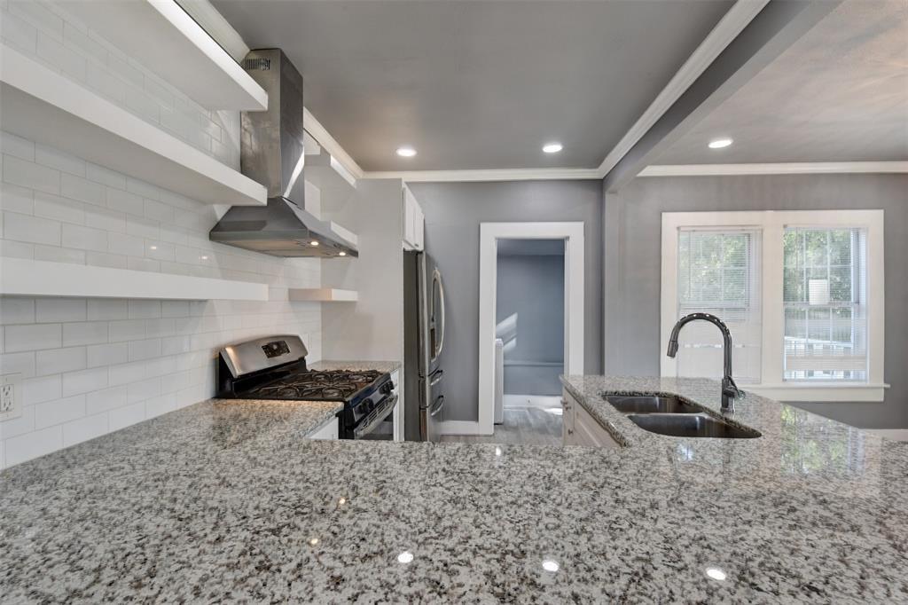 Kitchen with granite counters, double-basin sink, stainless steel appliances, and white subway tile backsplash.