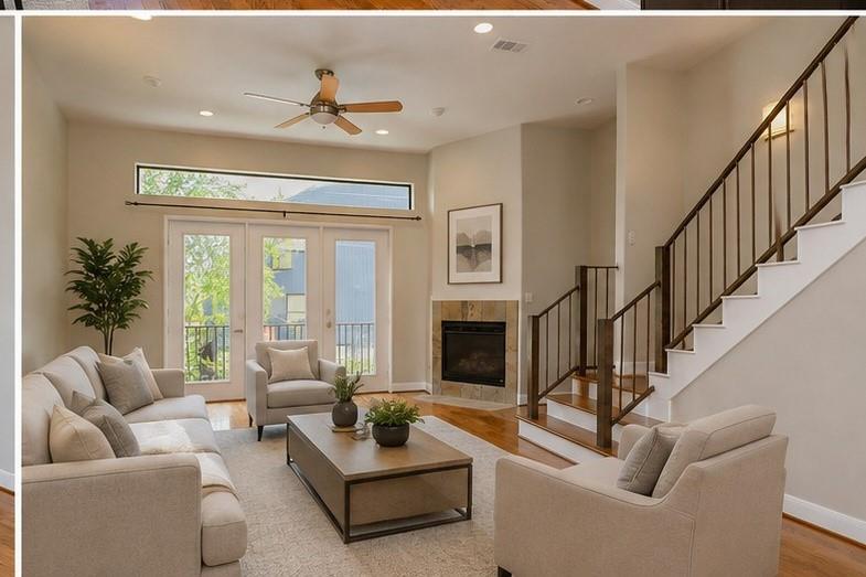 Living room with light seating, a fireplace, and a staircase with dark railings.