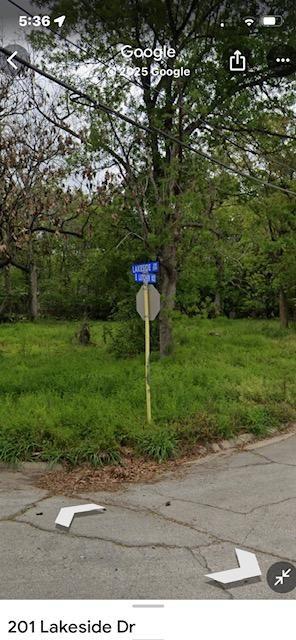 Tree-covered corner lot beside a cracked road, with a Lakeside Drive street sign.