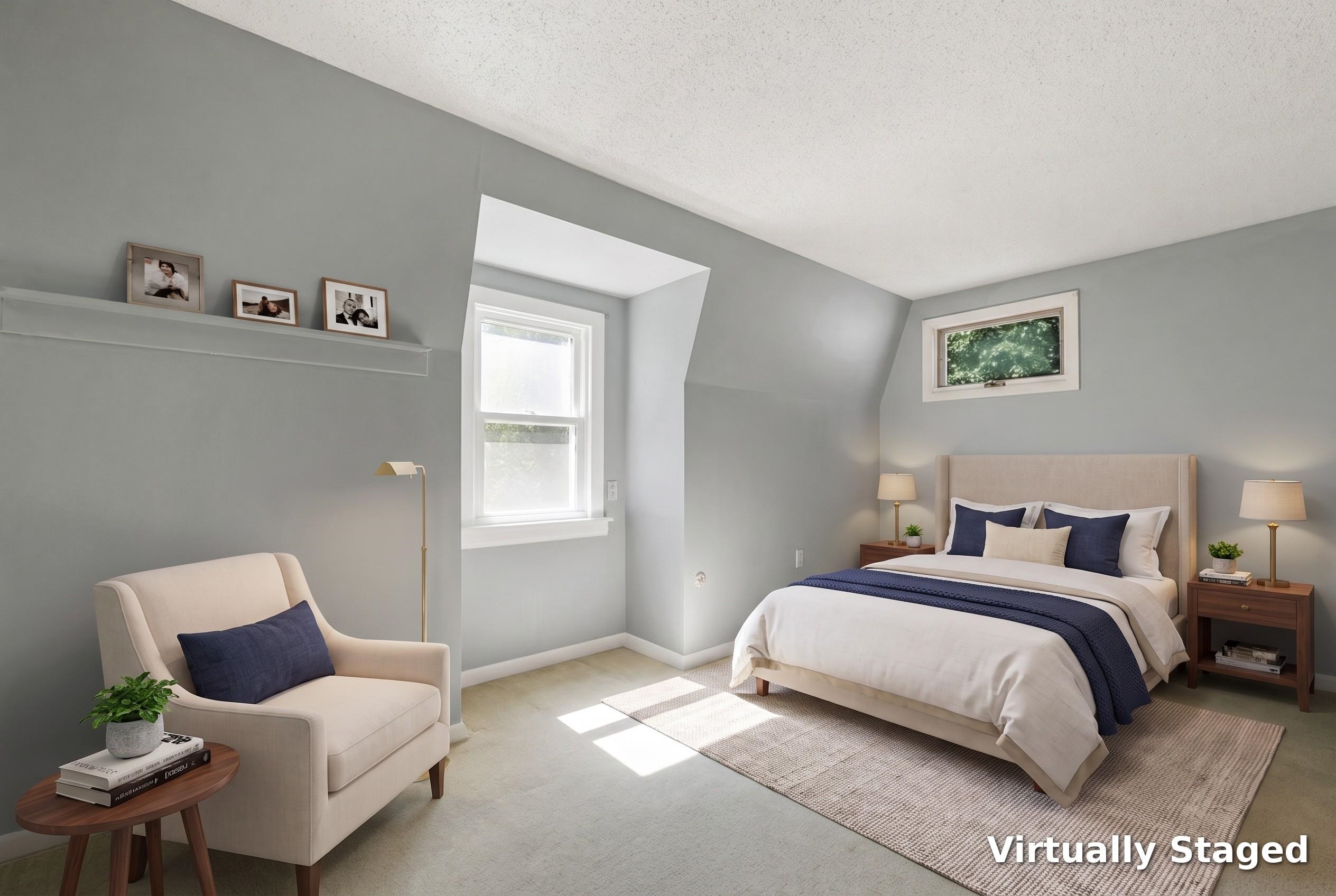 Virtually staged bedroom with a navy-and-white bed, gray walls, and a cream armchair.