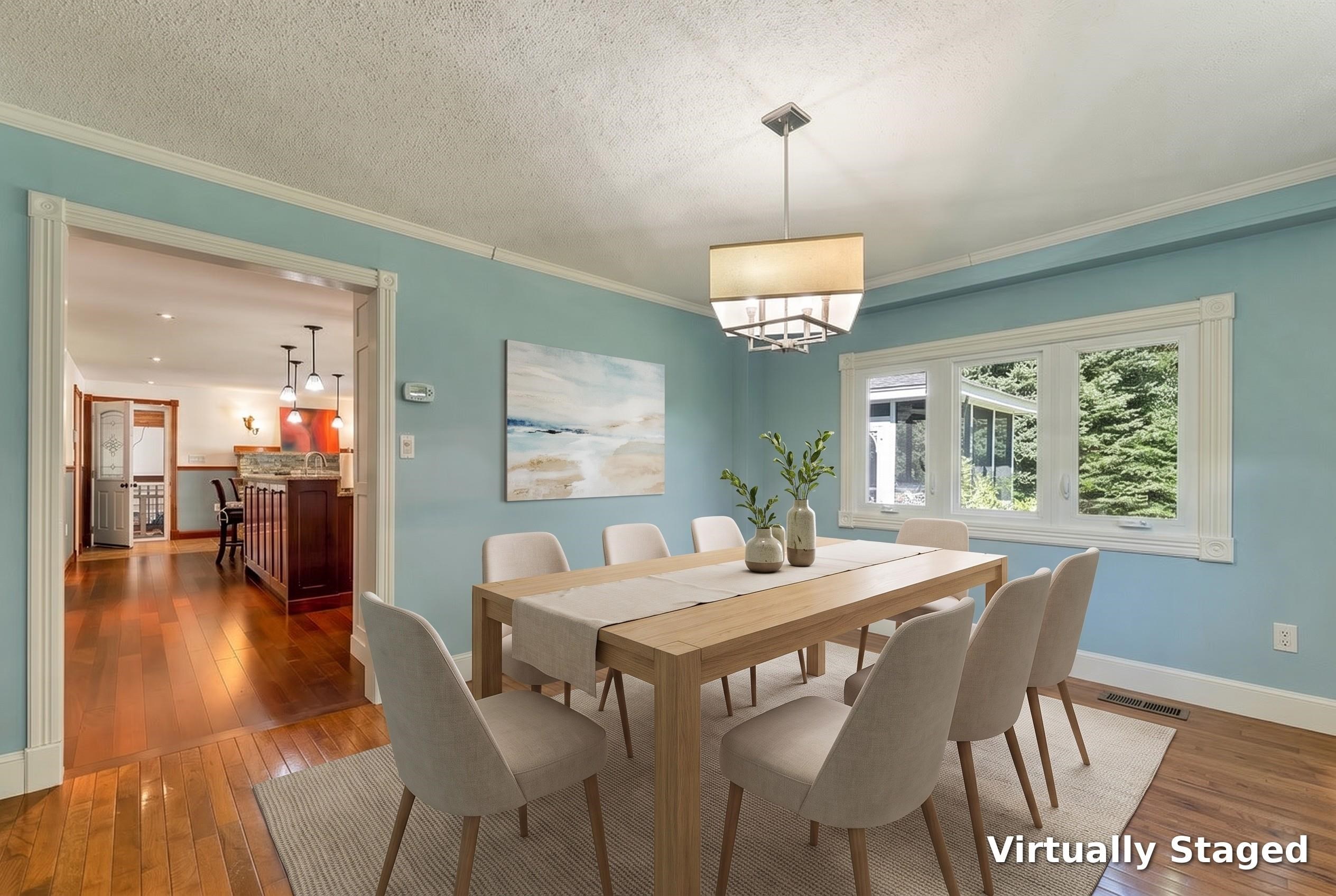 Dining room with a long wooden table, upholstered chairs, blue walls, and a large window.