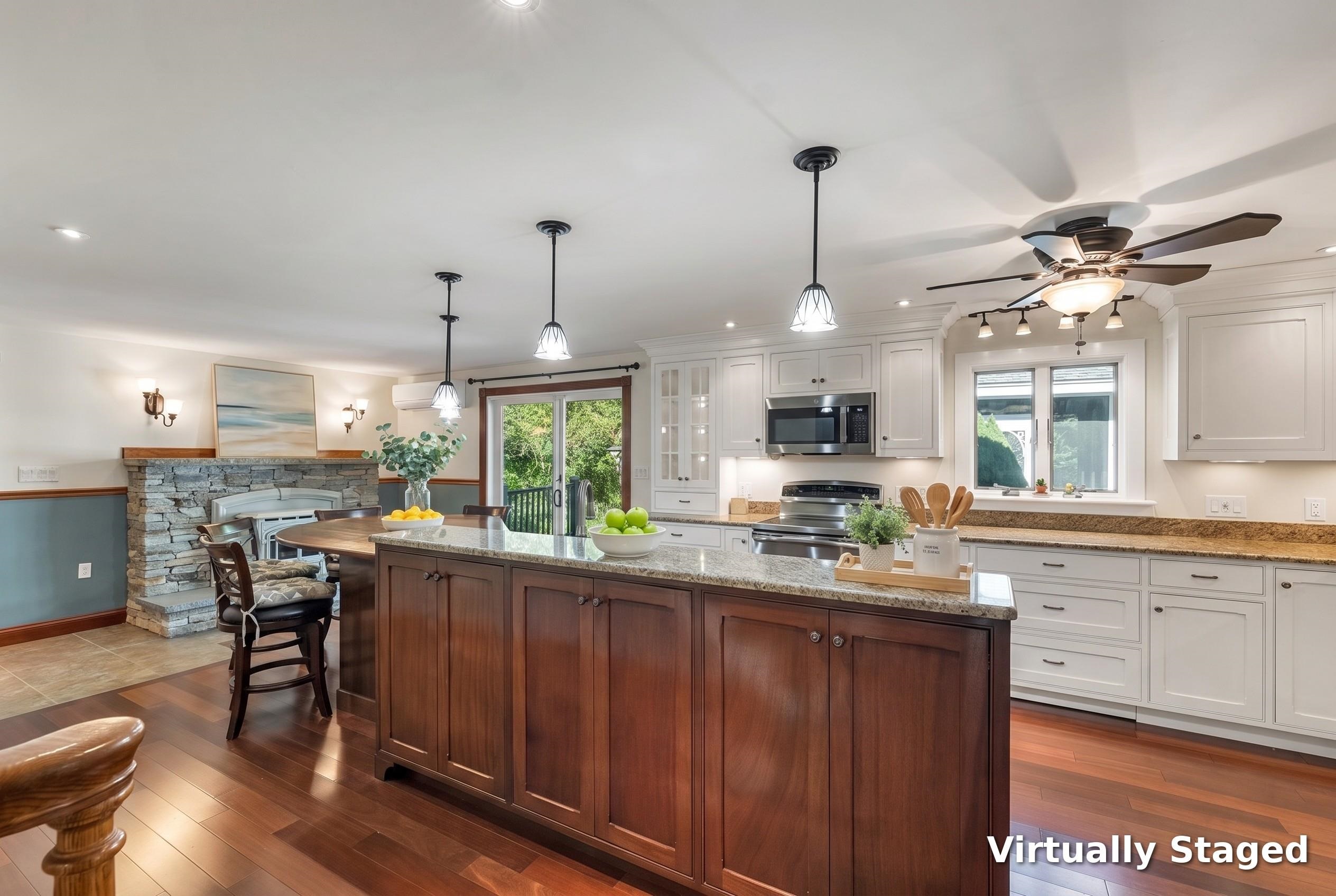 Virtually staged kitchen with a large dark wood island, white cabinets, granite counters, and a stone fireplace.