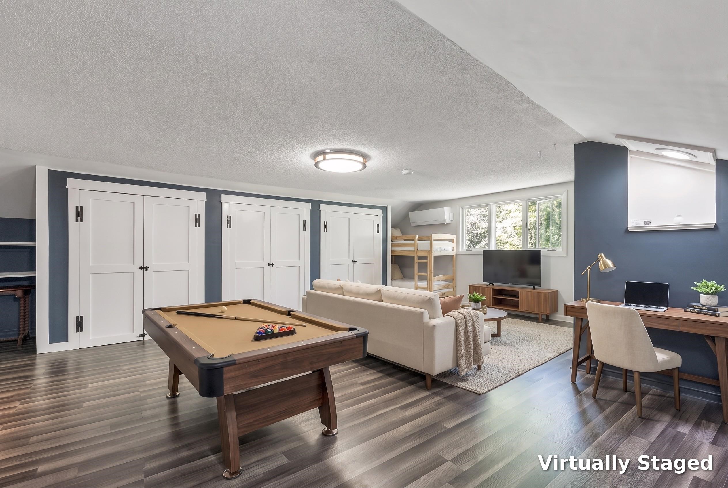 Basement recreation room with a pool table, bunk beds, sofa, and desk.