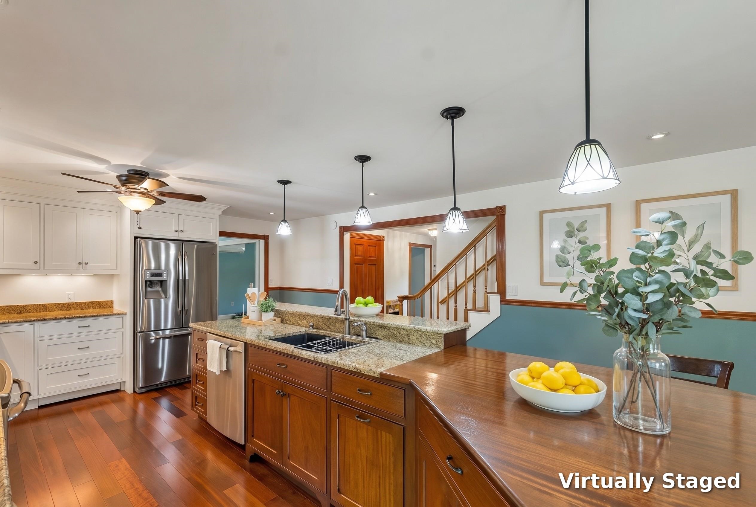Kitchen with granite counters, a wood island, stainless steel refrigerator, and hardwood floors.