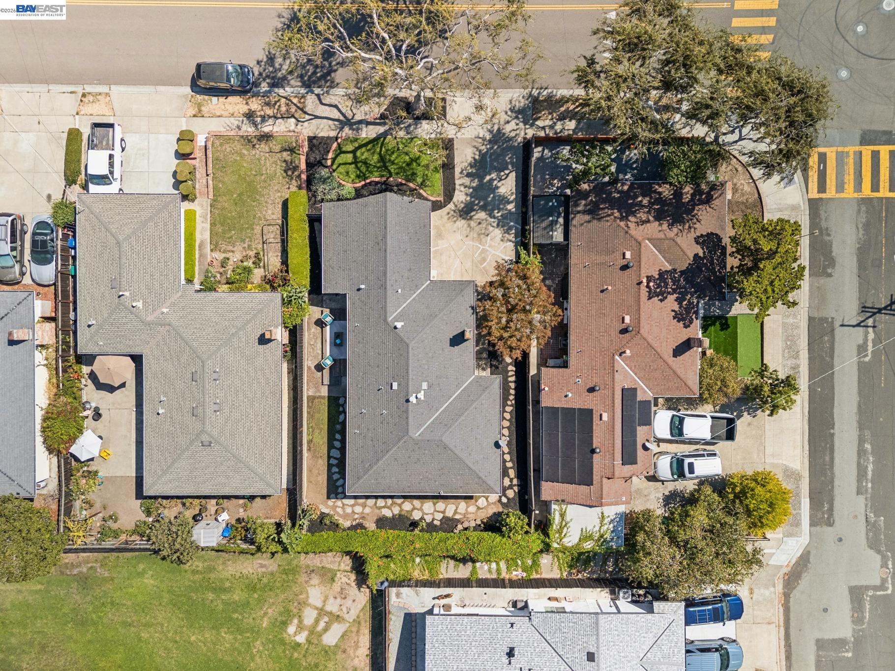Aerial view of a gray-roofed home with a landscaped yard and neighboring residences.