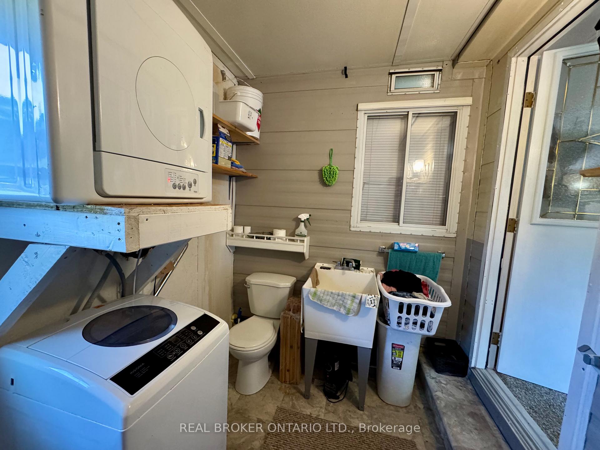 Laundry and utility room with washer, dryer, toilet, and utility sink.
