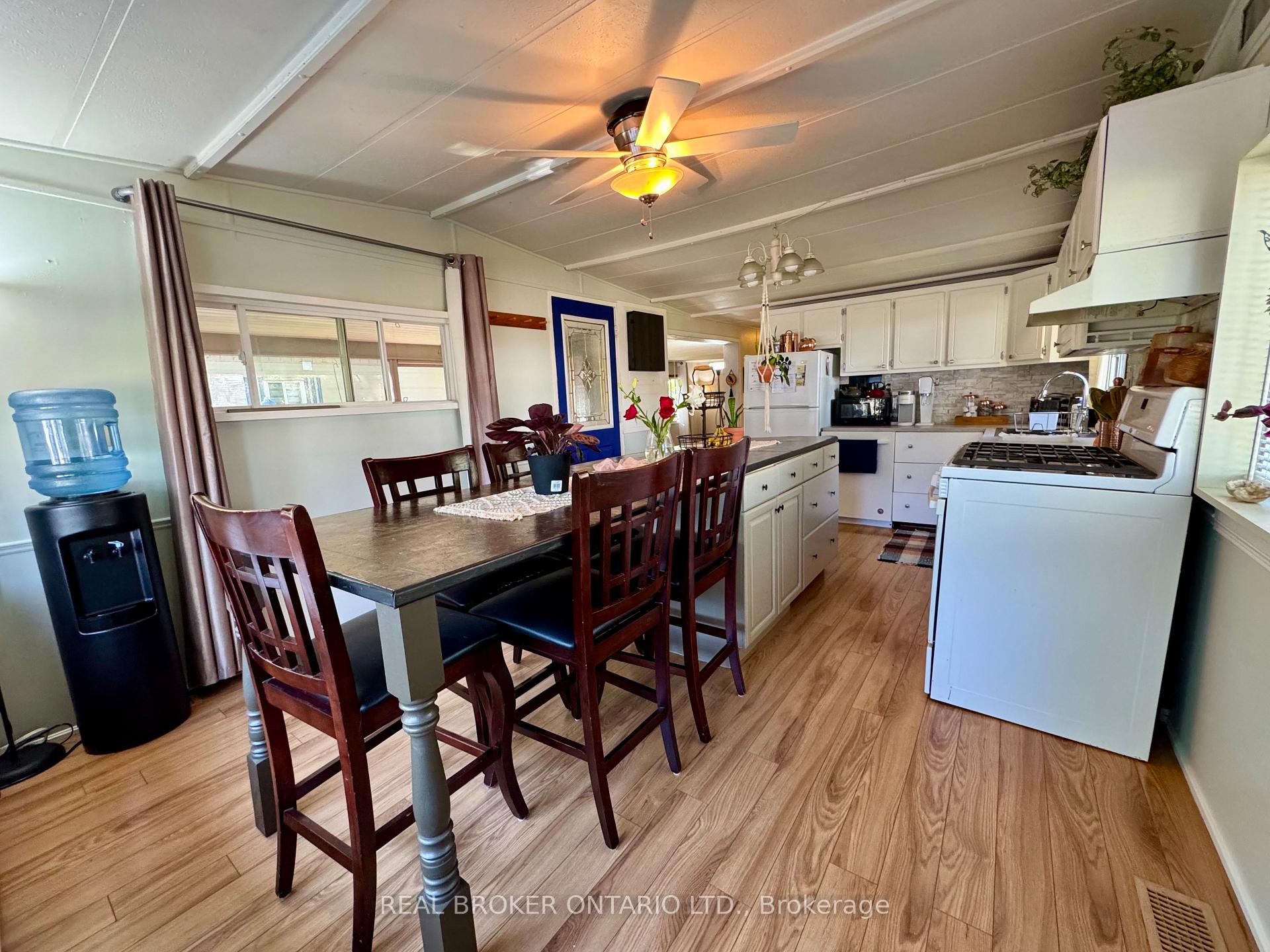 Furnished kitchen with a large gas range, white cabinetry, and an adjoining dining table with tall chairs.