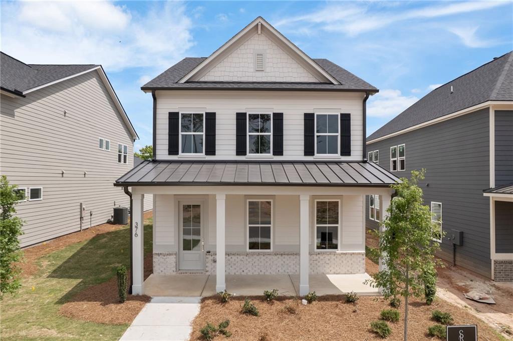 Two-story white house with black shutters and a covered front porch.