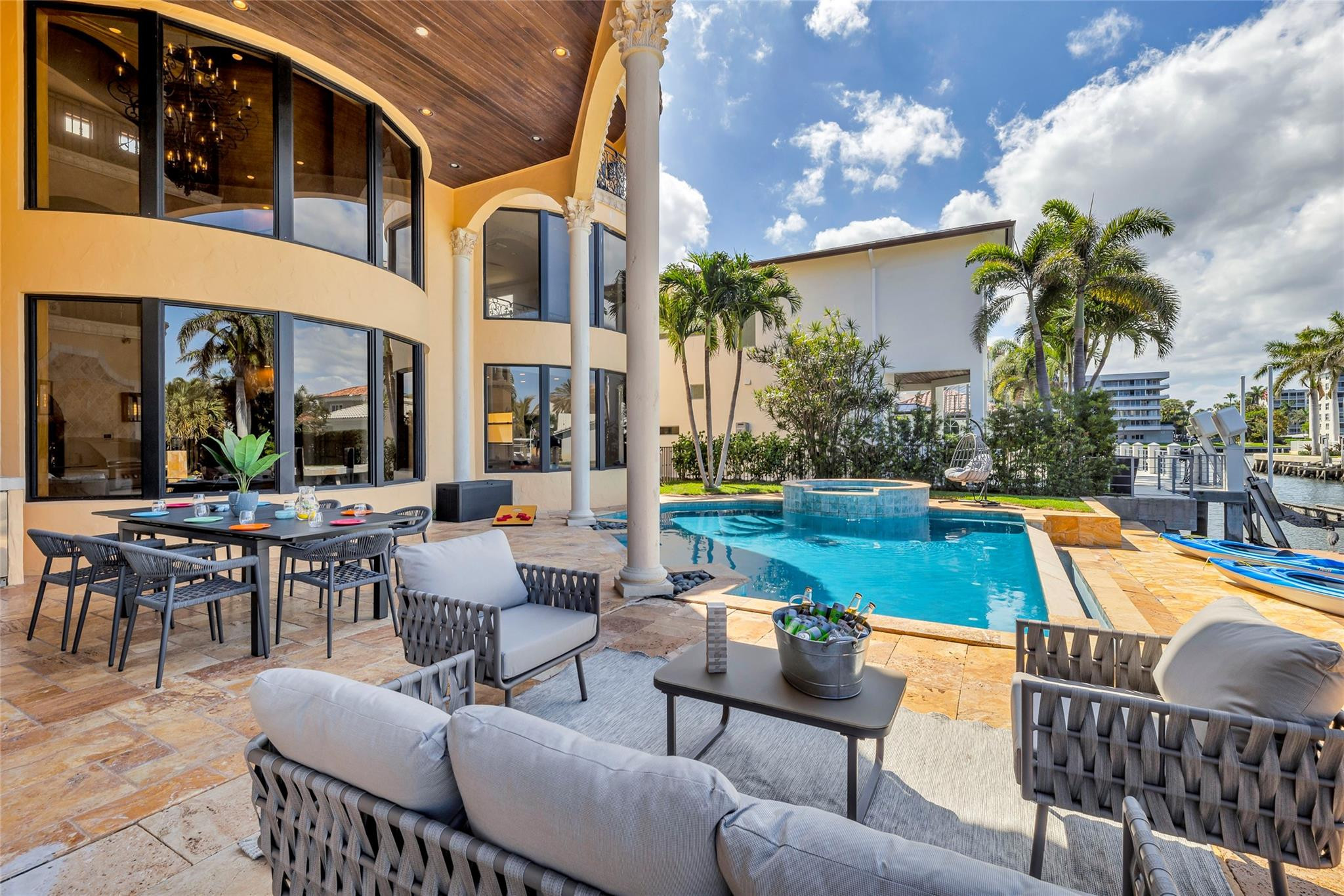 Waterfront pool and furnished patio with a raised spa, canal dock, and kayaks.