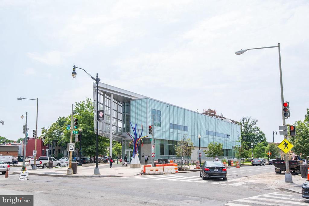 Shaw Library at a Washington, DC intersection, with glass walls and a colorful outdoor sculpture.