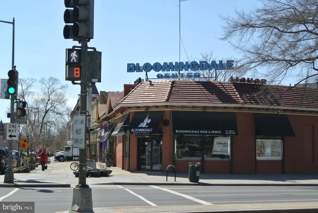 Bloomingdale Center storefront at a city intersection, with street signs and traffic lights.