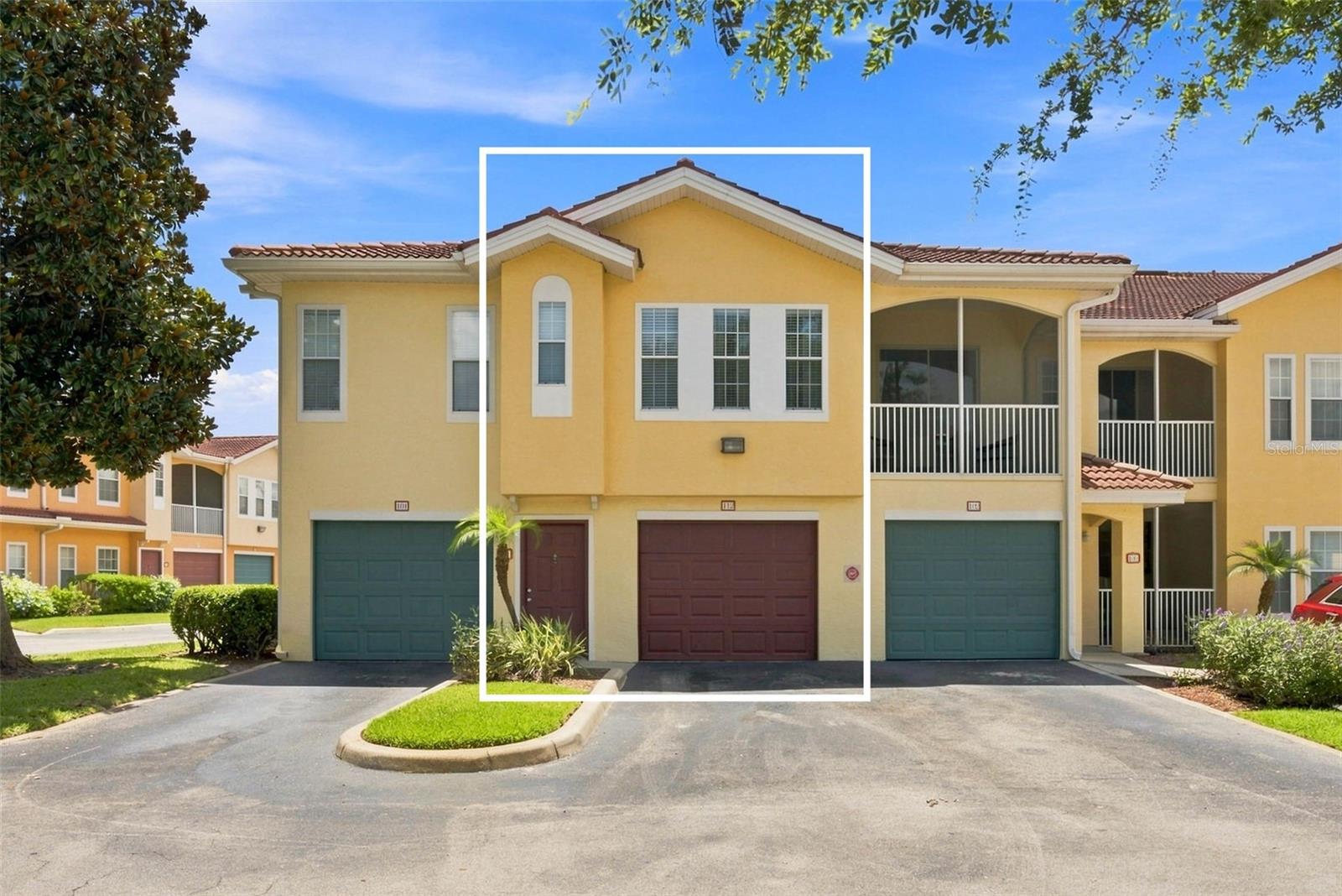 Yellow two-story townhouse highlighted by a white outline, with a red-brown garage door and front door.