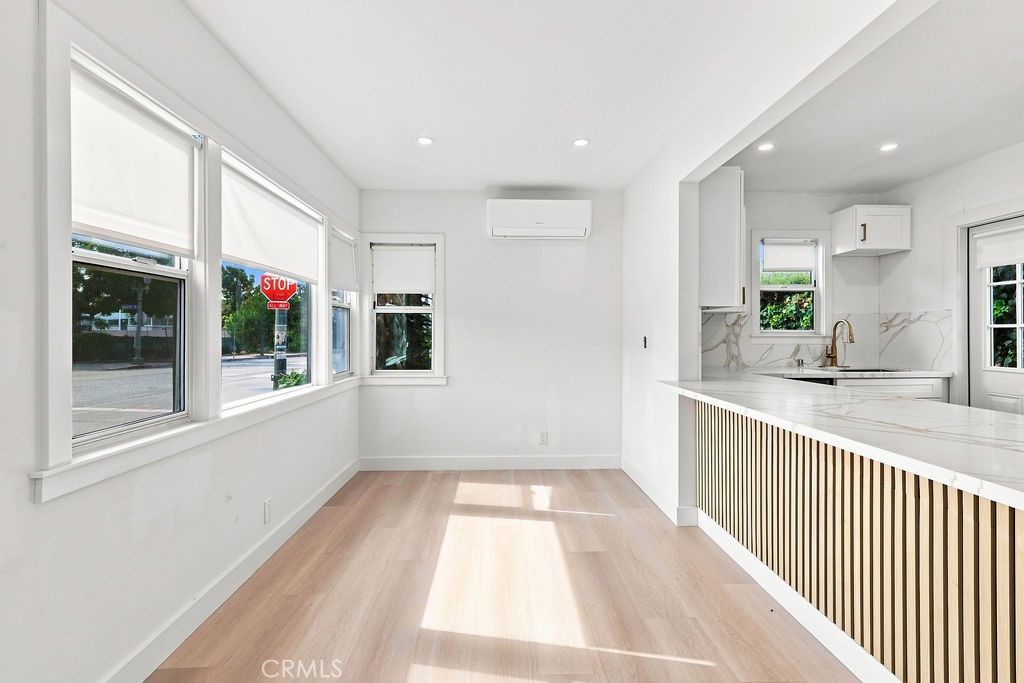 Bright kitchen and dining area with large windows and a marble-look breakfast bar.