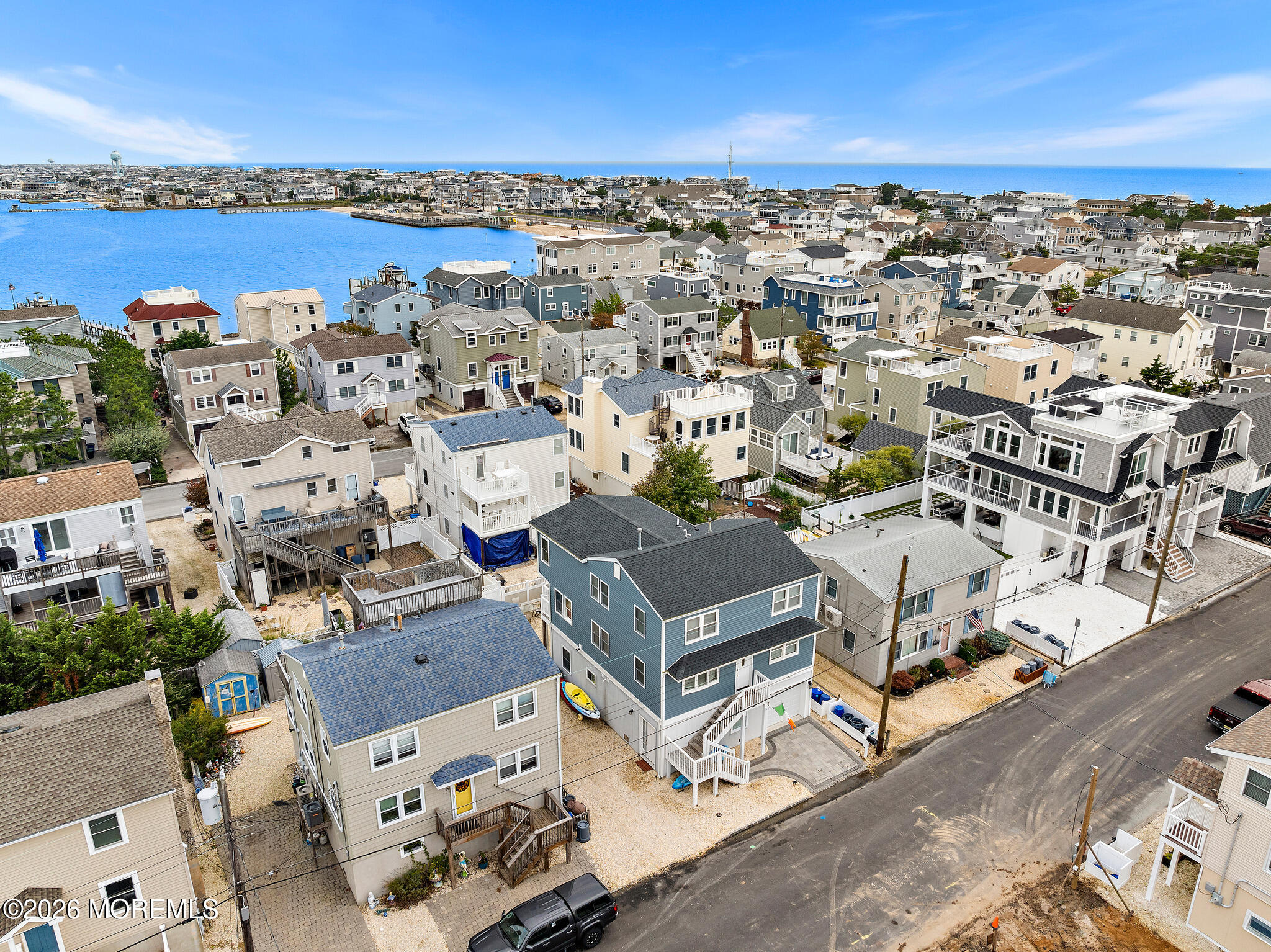 Aerial view of coastal homes beside a bay, with the ocean on the horizon.