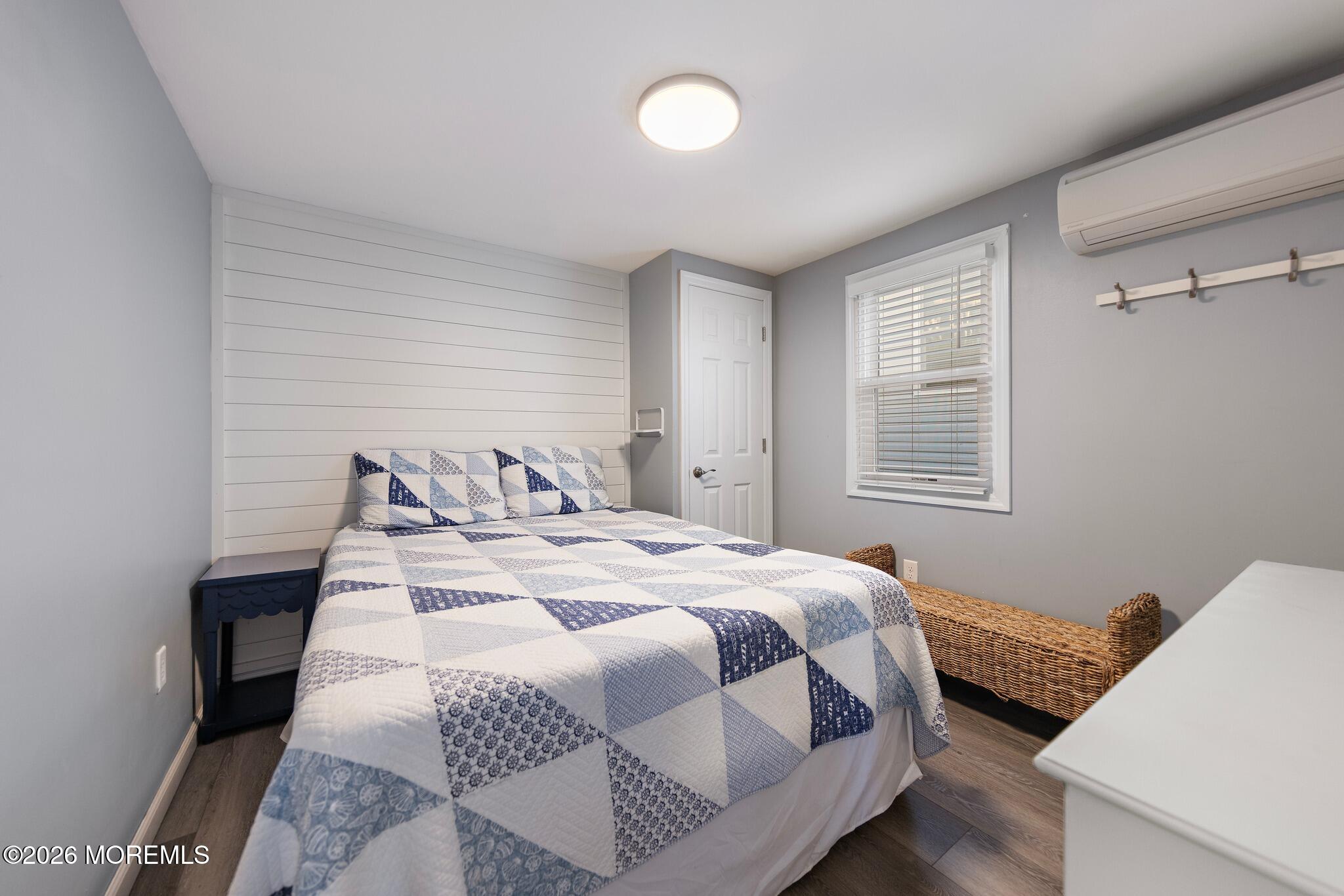 Bedroom with a blue-and-white quilted bed against a white shiplap accent wall.