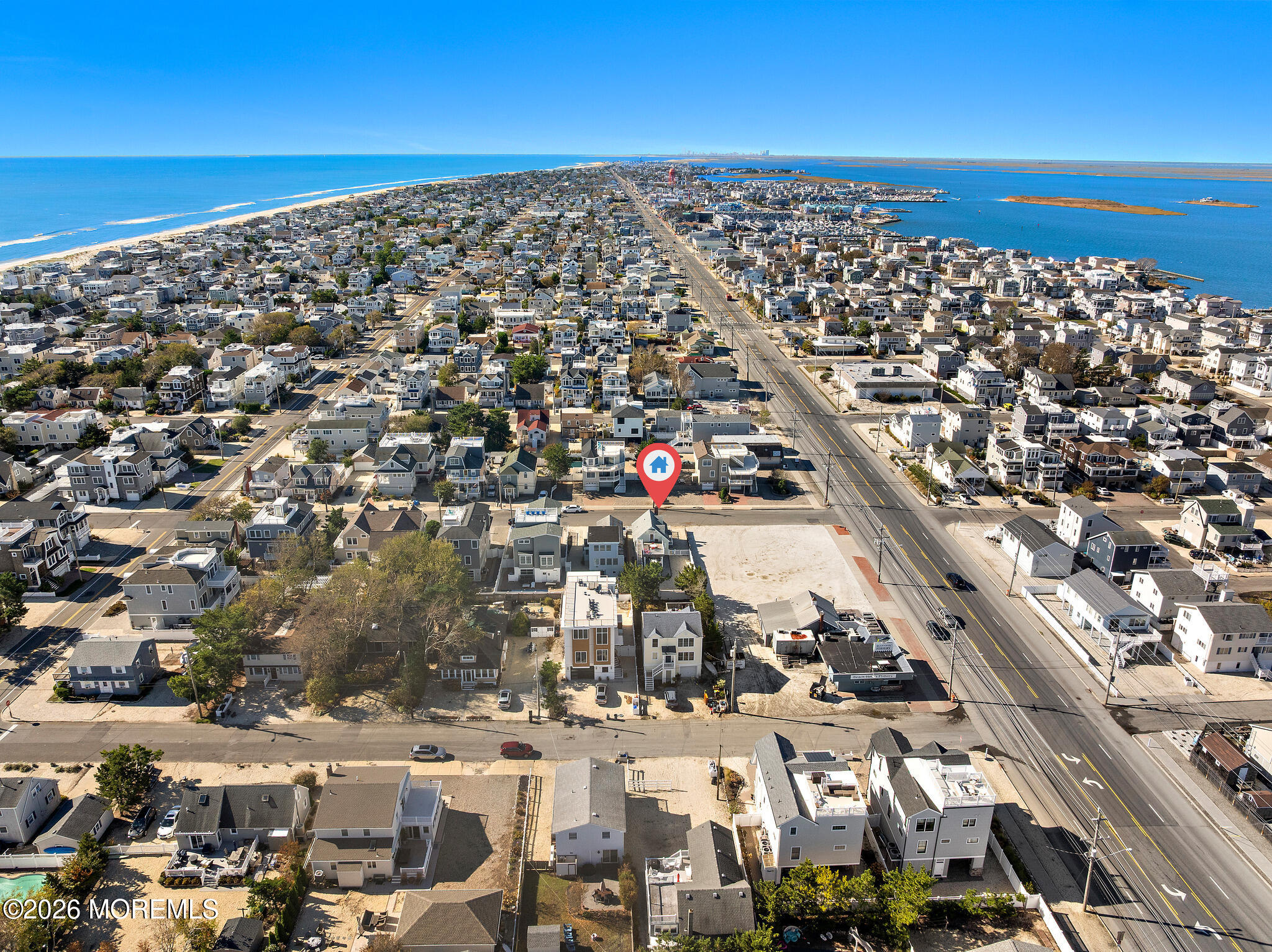 Aerial view of Long Beach homes, with a map pin marking the property between ocean and bay.