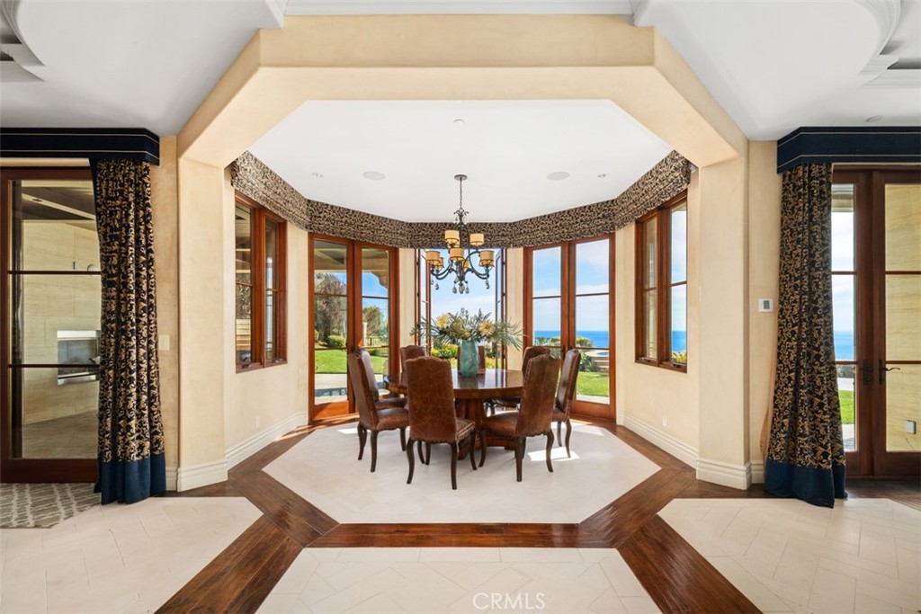 Formal dining room with tall windows overlooking the lawn and ocean.