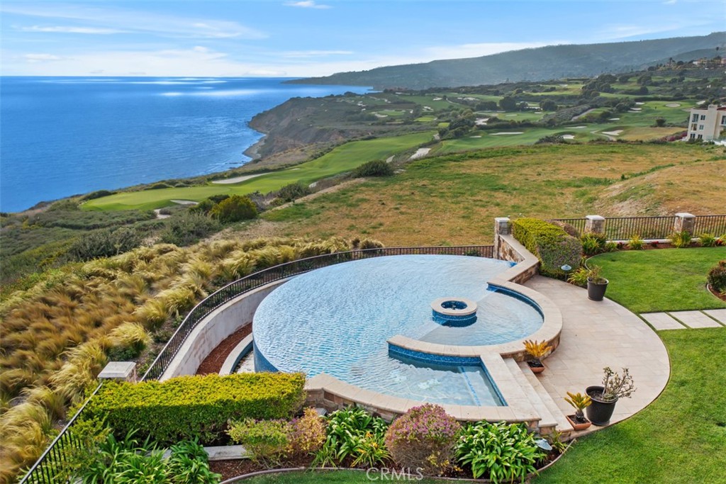 Coastal swimming pool overlooking ocean cliffs and golf course fairways.