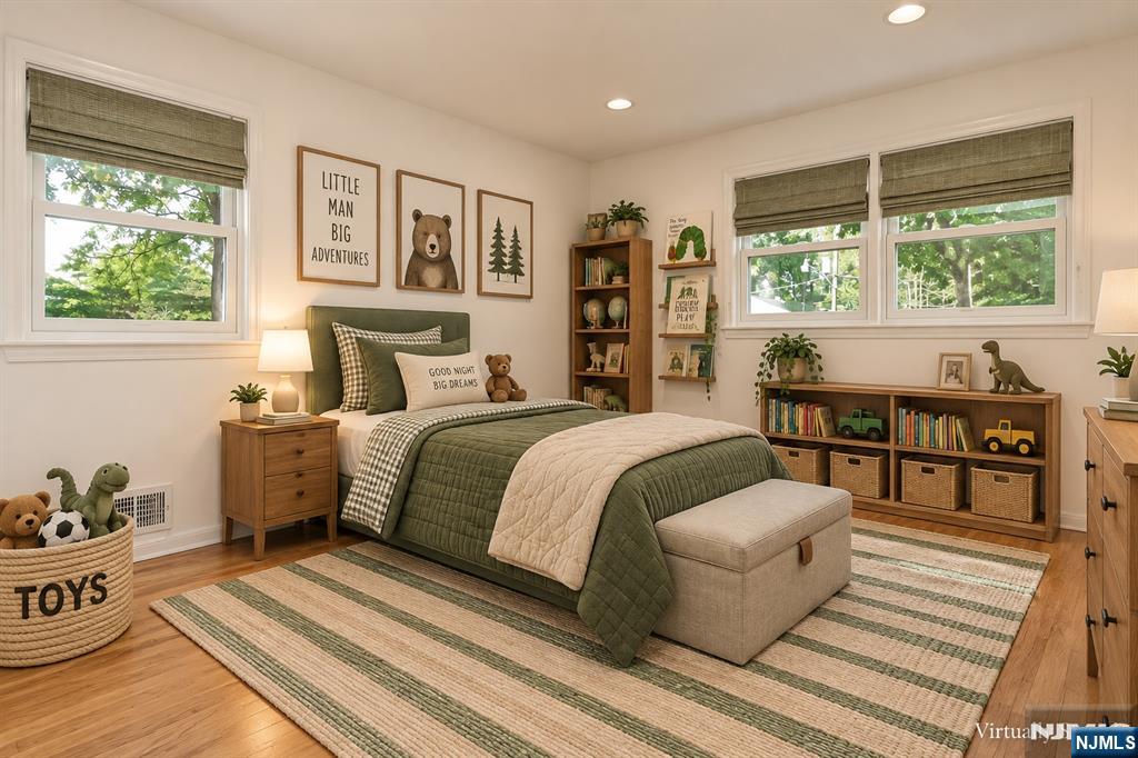Staged child's bedroom with green bedding, woodland prints, and shelves of books and toys.