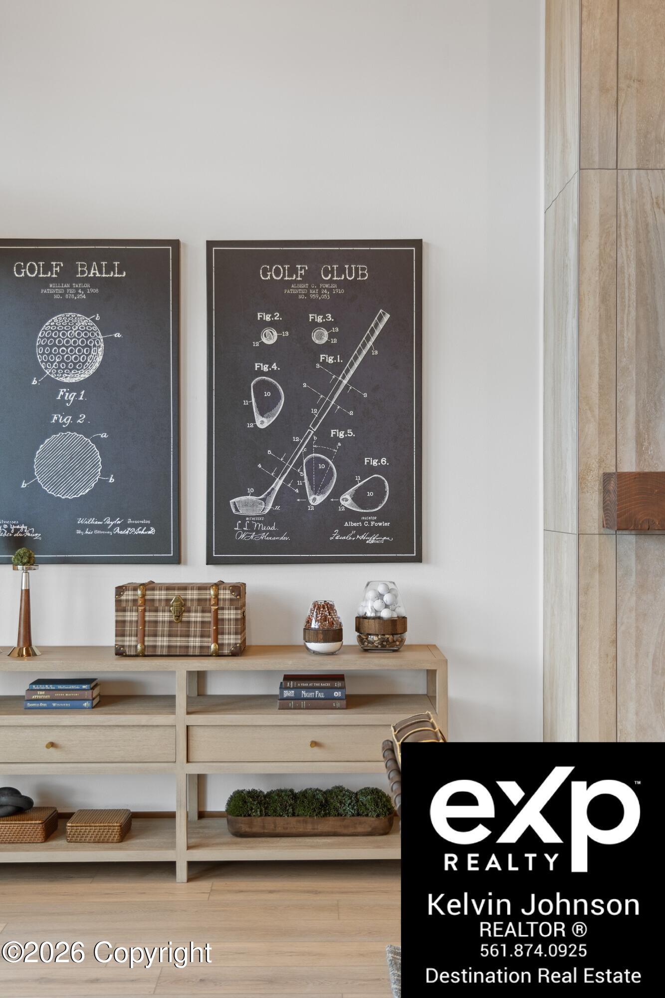 Interior console with framed golf patent prints, a plaid trunk, books, and golf-themed decor.