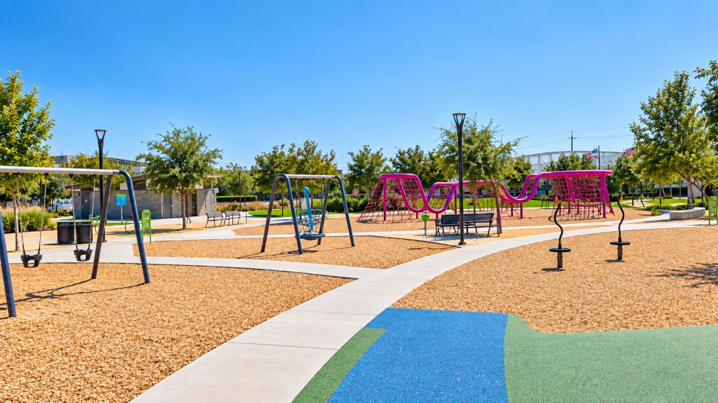 Neighborhood playground with swings, a pink climbing structure, and curving concrete paths.