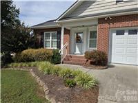 Home exterior with brick façade, white garage door, and landscaped front garden.