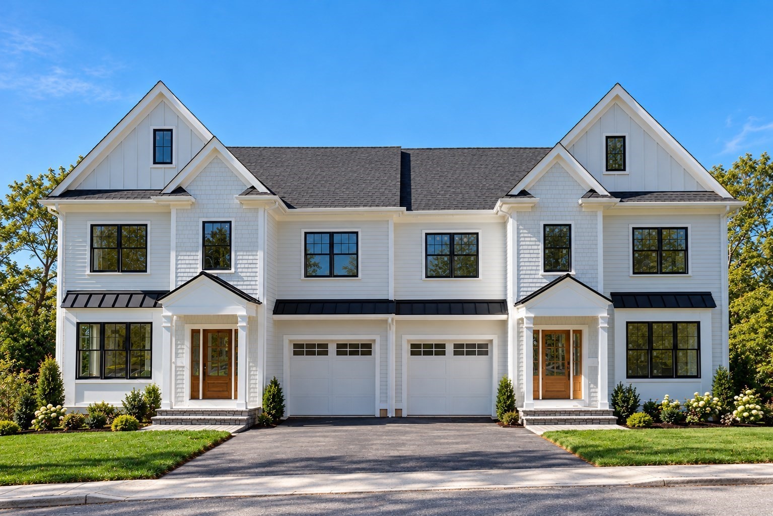 White two-story attached home with twin gables, black-framed windows, and two garage doors.