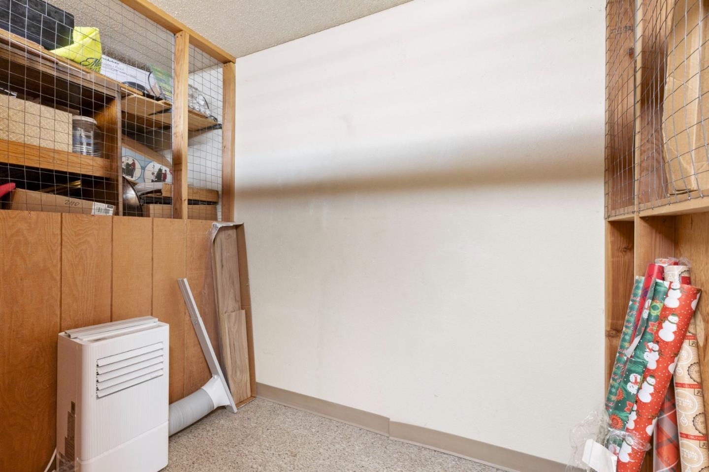 Storage room with wire-mesh shelving, household items, and a portable heater.