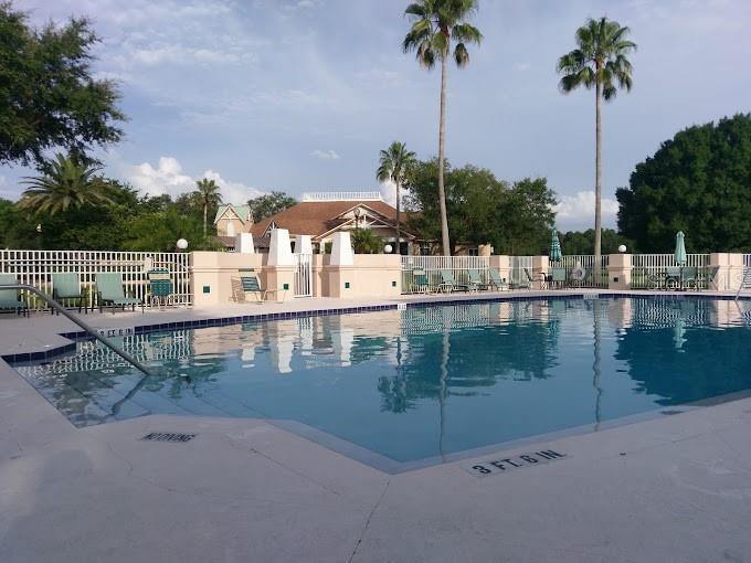 Outdoor swimming pool with lounge chairs, palm trees, and a 3-foot depth marker.