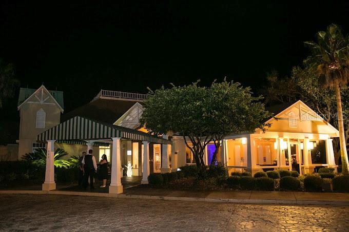 Building exterior at night with a striped entrance canopy and warmly lit windows.
