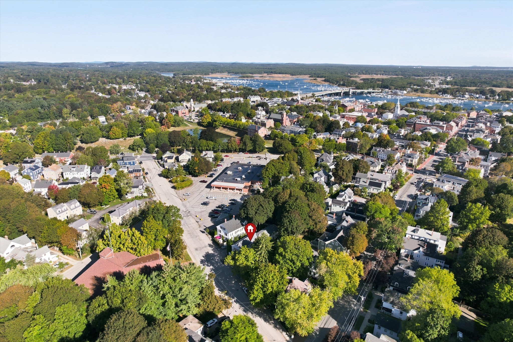 Aerial view of the marked home amid a leafy neighborhood near the harbor.